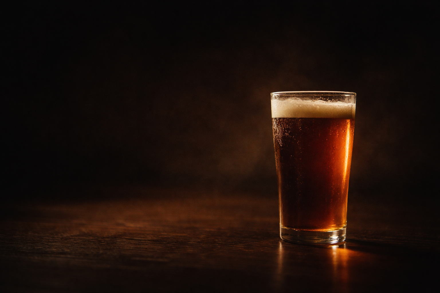 静かな空間に置かれた琥珀色のビールグラス